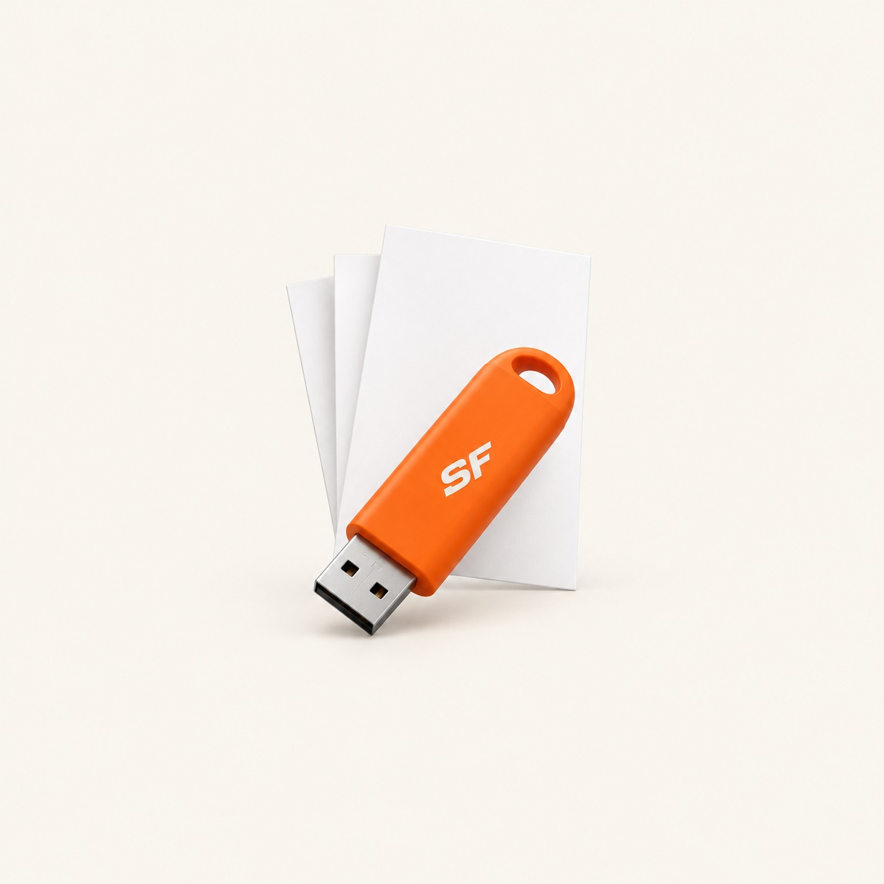 An orange USB stick with the letters SF lying on some sheets of paper